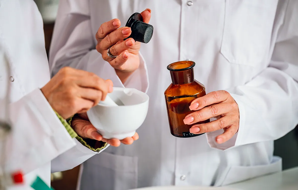 Neprepoznatljive farmaceutkinje pripremaju lijekove; koncept galenski i magistralni pripravci