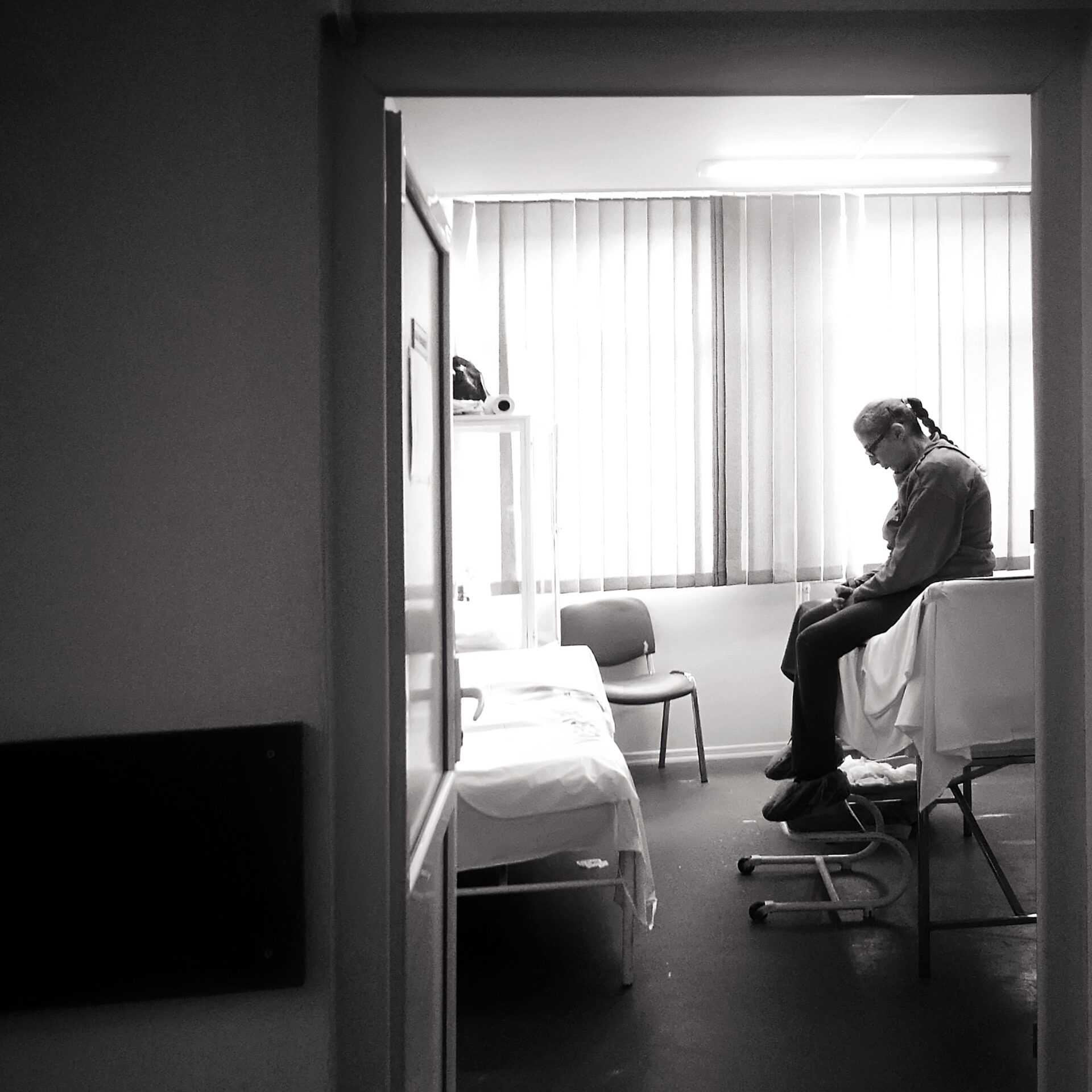 Muškarac sjedi na krevetu pognute glave u bolničkoj sobi; koncept kolektivni otkaz u DZ Trebnje u Sloveniji