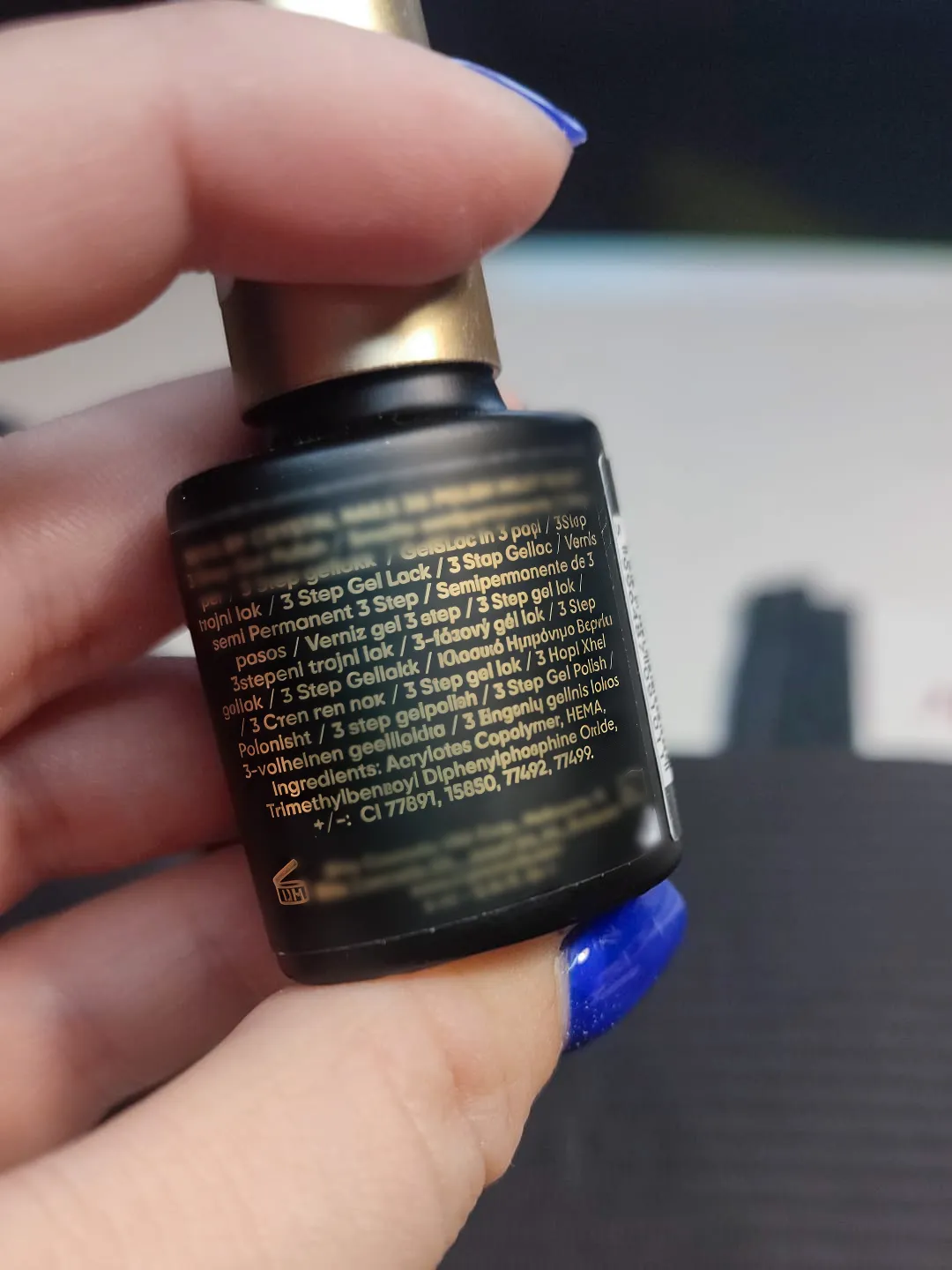 Bočica gel laka u ruci u krupnom planu; koncept toksičnost TPO-a