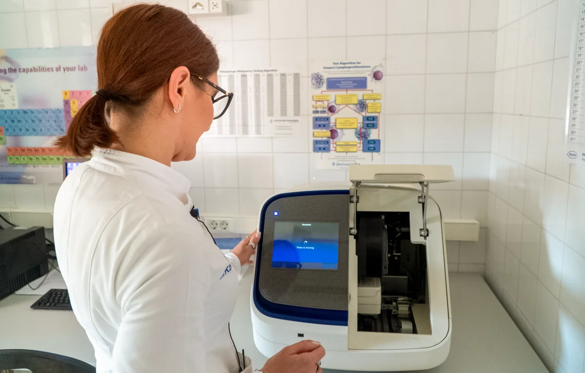 molekularna-patologija-KBC-Split Liječnica Kliničkog zavoda za patologiju, sudsku medicinu i citologiju KBC-a Split, gdje se provodi molekularna patologija, u bijeloj kuti okrenuta leđima gleda u medicinski aparat.