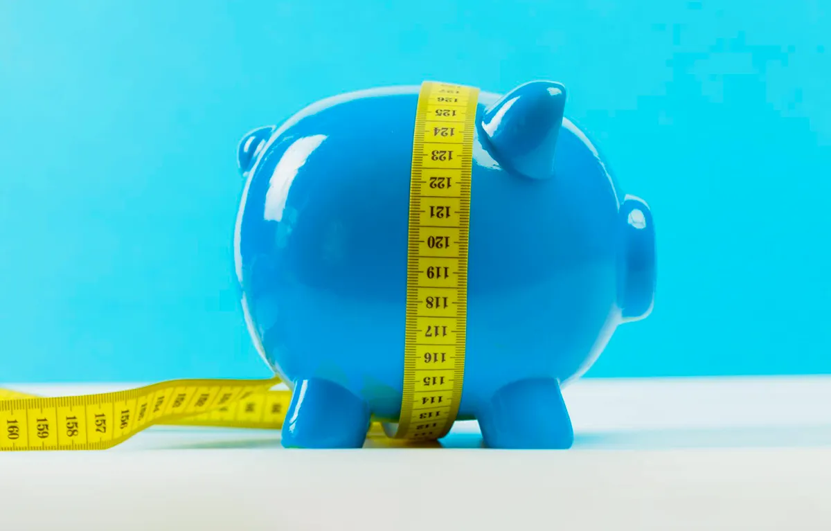 potrosnja-na-semaglutid Plava kasica prasica s omotanim metrom za mjerenje; koncept semaglutid potrošnja u RH