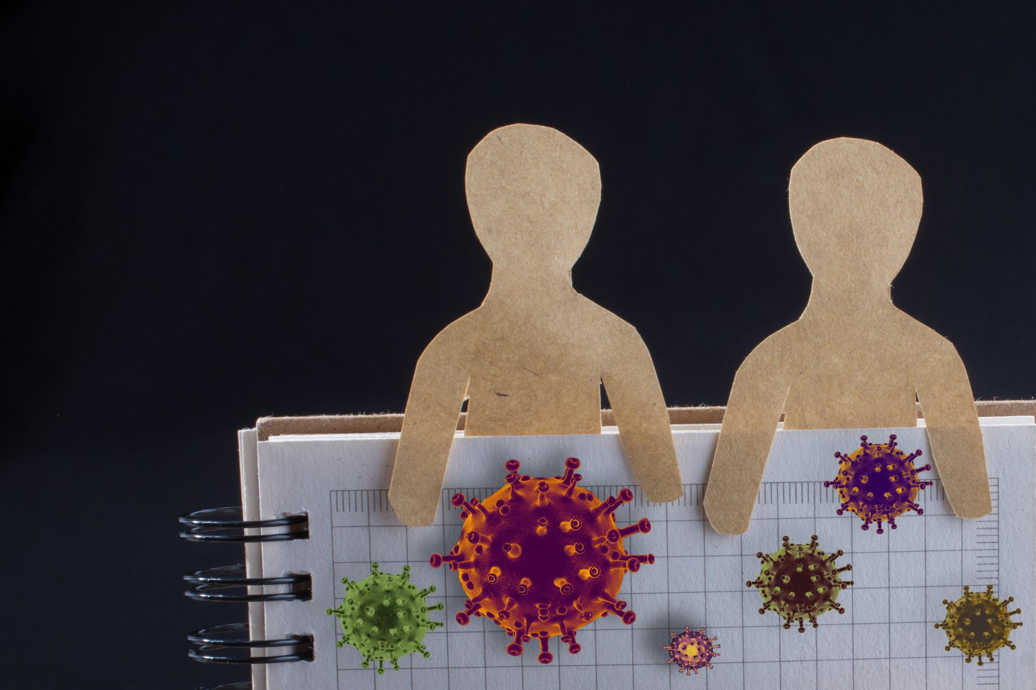 američka zdravstvena politika Dva lika od kartona drže papir s nacrtanim virusima i bakterijama.