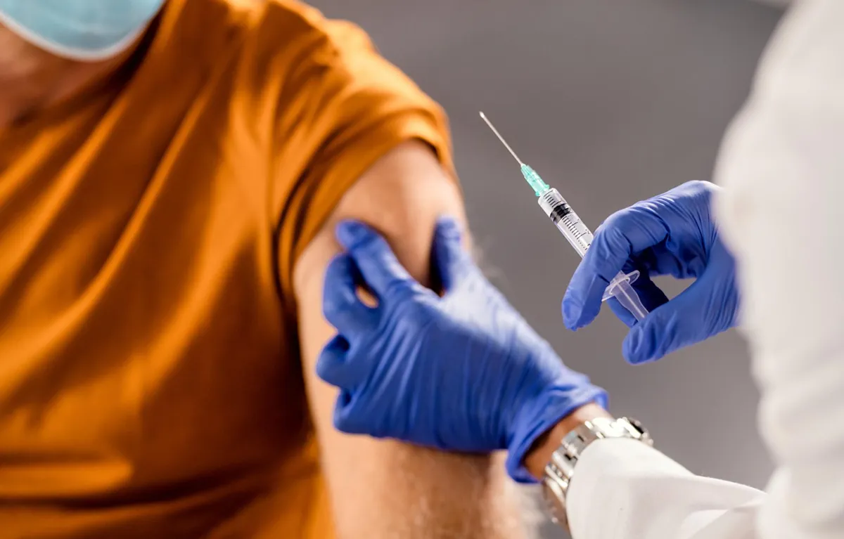 jedno-cjepivo Medicinska djelatnica pacijentu daje cjepivo u nadlakticu; koncept dvostruko cijepljenje