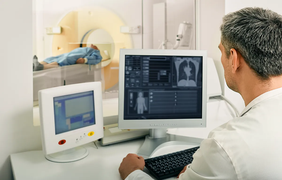 Liječnik analizira CT ili PET/CT snimke pluća pacijenta na računalu u dijagnostičkom odjelu; ; koncept lijekovi za mršavljenje PET/CT