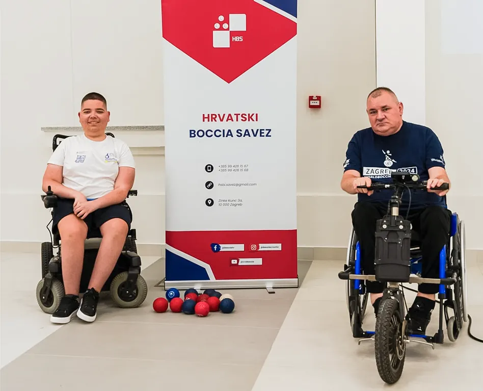 Dvije osobe s invaliditetom pored roll-up bannera Hrvatskog boccia saveza