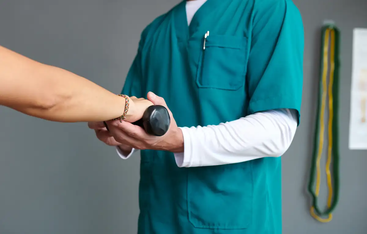 Srednji plan, fizijatar pomaže pacijentici u vježbi s utezom u ruci; ENEA program