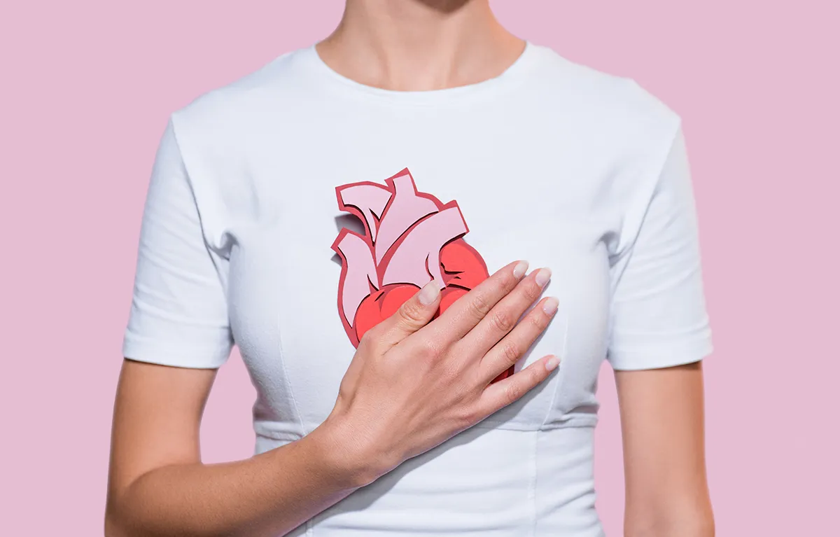 Neprepoznatljiva žena drži anatomski prikaz srca od papira na grudima; Tehnika zračenja u dubokom udahu, zračenje ranog raka dojke