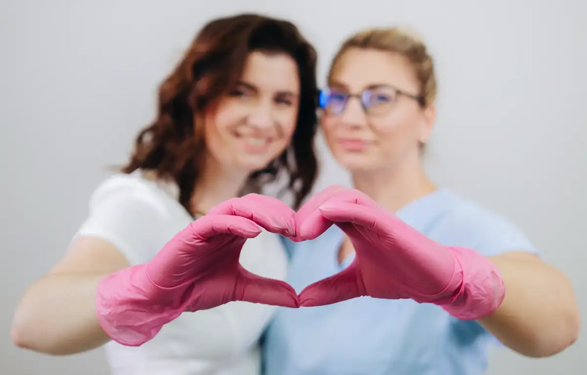 uzv-dojke-kbc-rijeka Dvije medicinske djelatnice s rozim rukavicama rukama pokazuju srce; UZV dojki i mamografija bez uputnice u KBC Rijeka