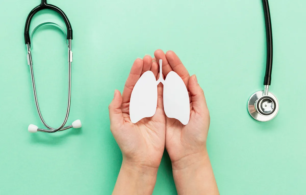 KOPB-Crikvenica-najava Stetoskop na zelenoj podlozi i slika pluća u otvorenim šakama; koncept KOPB edukacija u Crikvenici