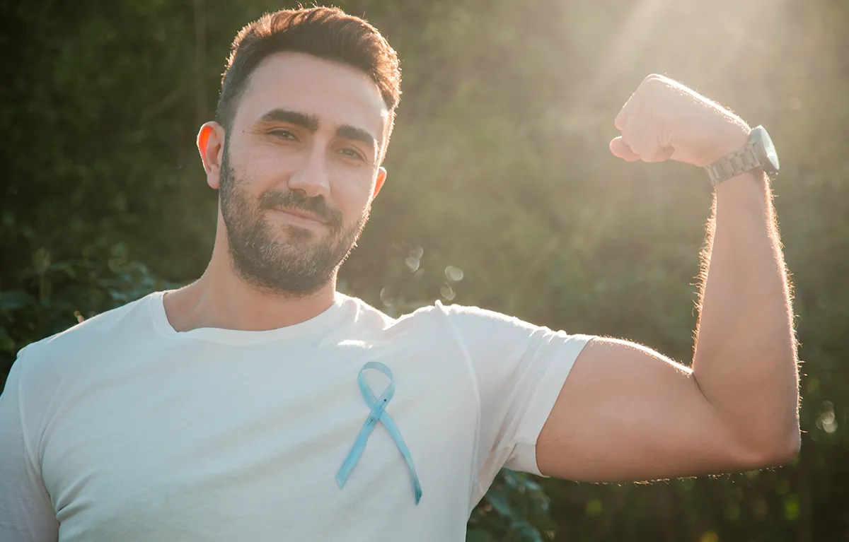 Muškarac pozira s podignutom rukom u znak snage i borbe protiv raka prostate; koncept Movember, rak prostate