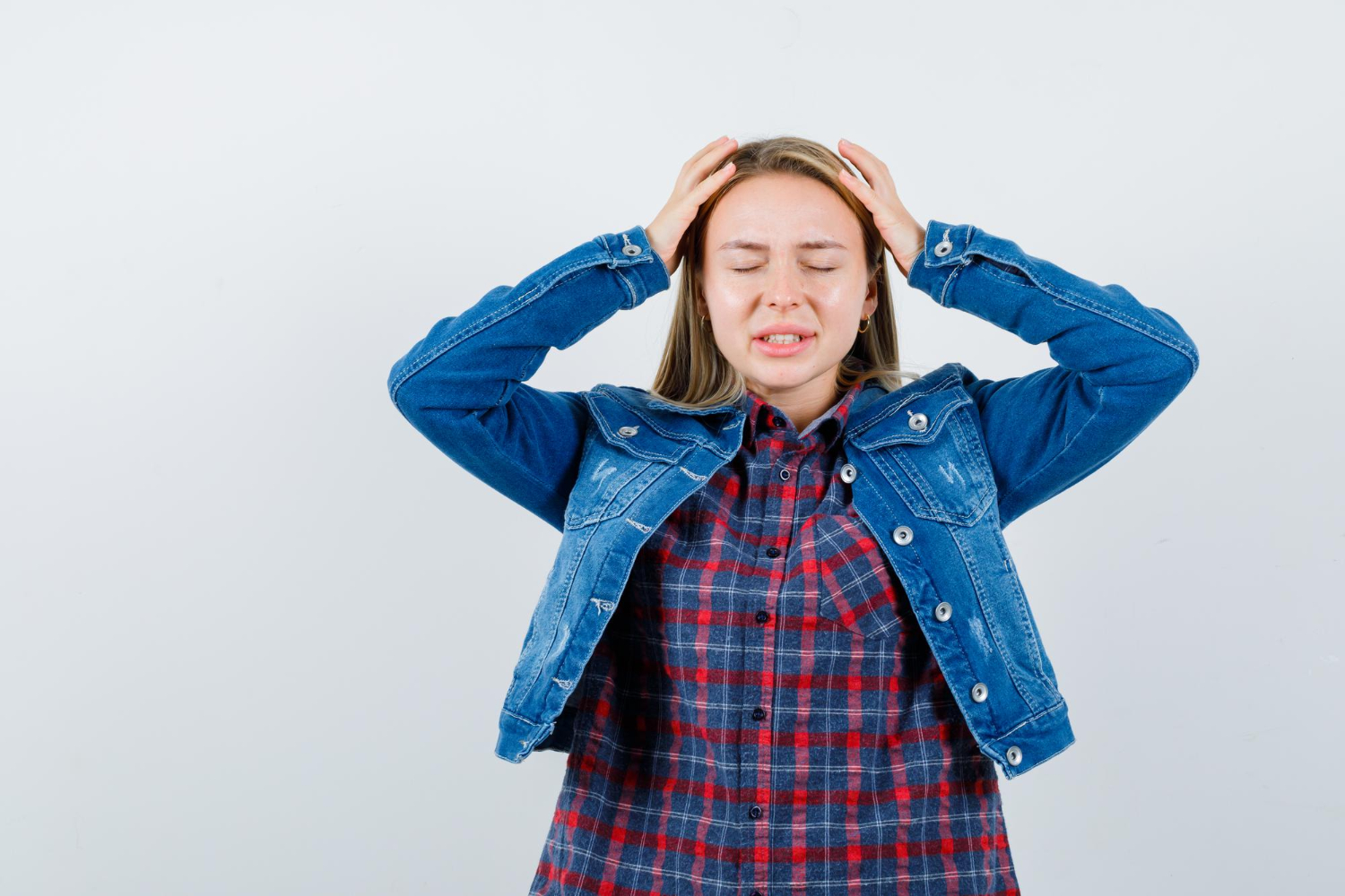 Glavobolja kod tinejdžera Djevojčica se rukama drži za glavu s obje strane. Koncept; glavobolja kod tinejdžera.