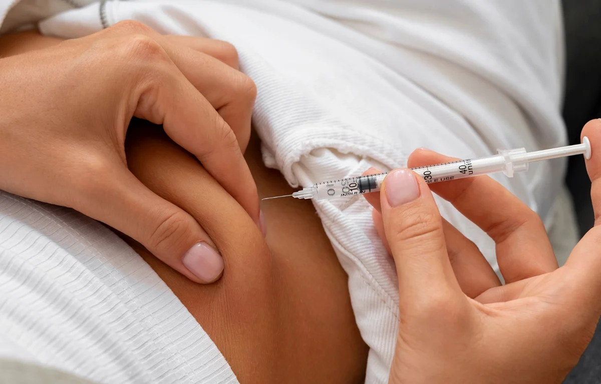 Lijekovi za mršavljenje, ženska ruka daje si lijek GLP-1 u trbuh; koncept proizvodnja lijekova za mršavljenje.