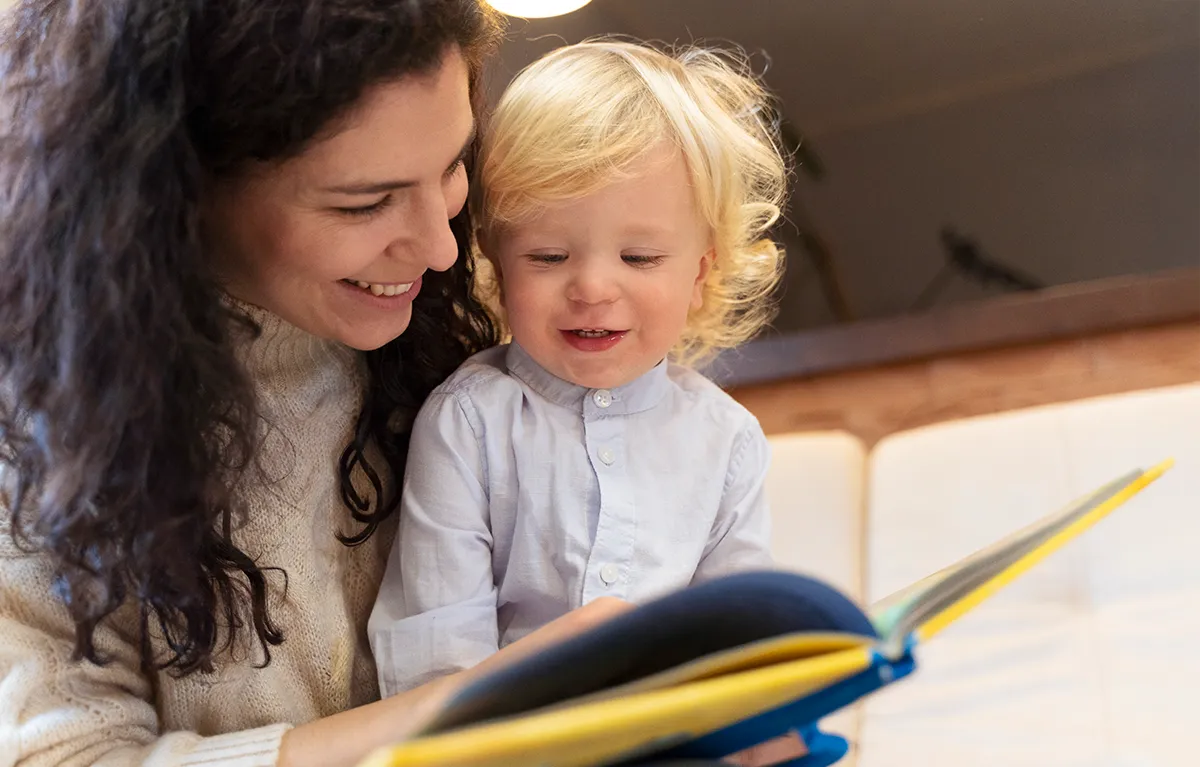 citanje-djeci-majka-sin Majka i malo dijete listaju knjigu i smiju se; koncept čitanje djeci