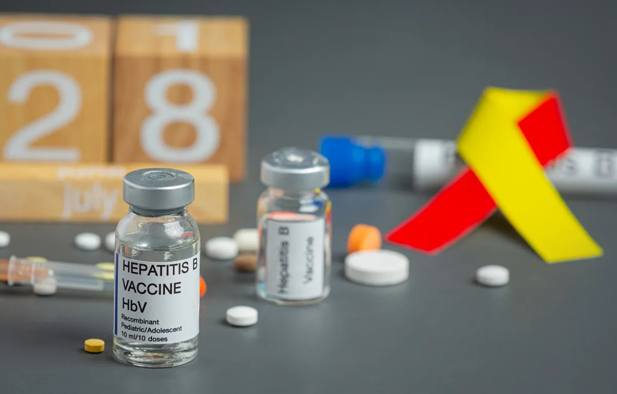 Prikaz cjepiva protiv hepatitisa B i mašnu kao simbol svjesnosti o raku; cjepljenje protiv hepatitisa B u SAD-u