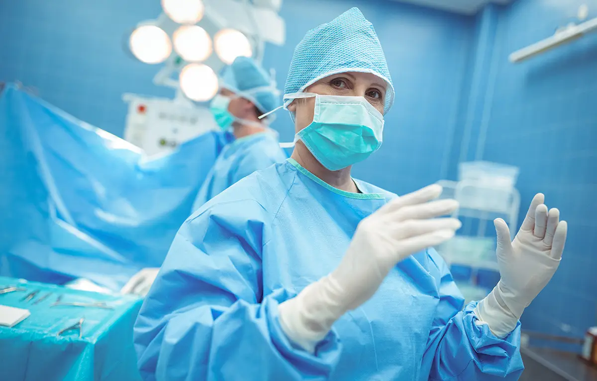 Kirurginja u operacijskoj sali, gleda u kameru