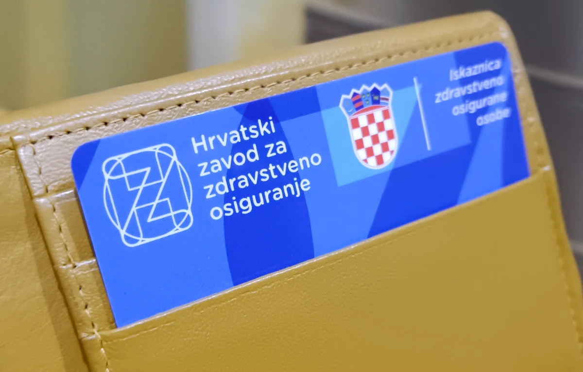 HZZO-iskaznica Iskaznica obveznog zdravstvenog osiguranja HZZO-a u novčaniku u krupnom planu; koncept novi lijekovi Osnovna lista lijekova i pomagala, kompresijski grudnjak