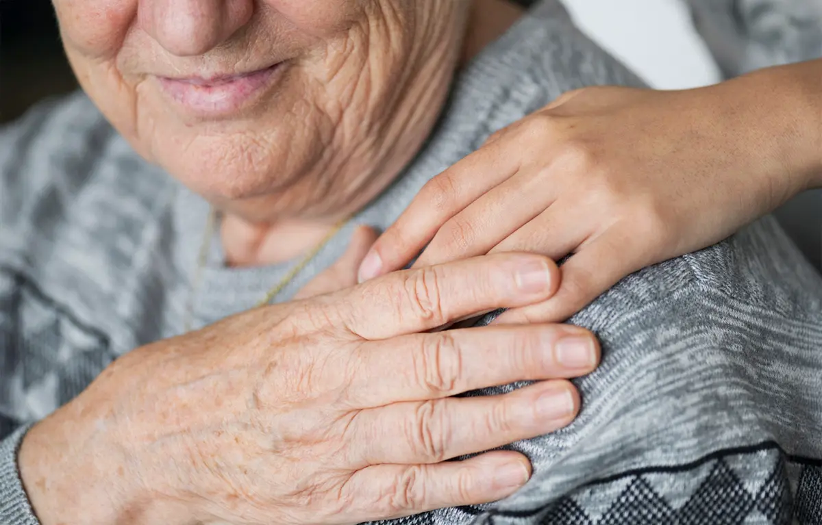 Ruka na ramenu starije osobe. Koncept gerontodomaćice; Županijska udruge slijepih Split