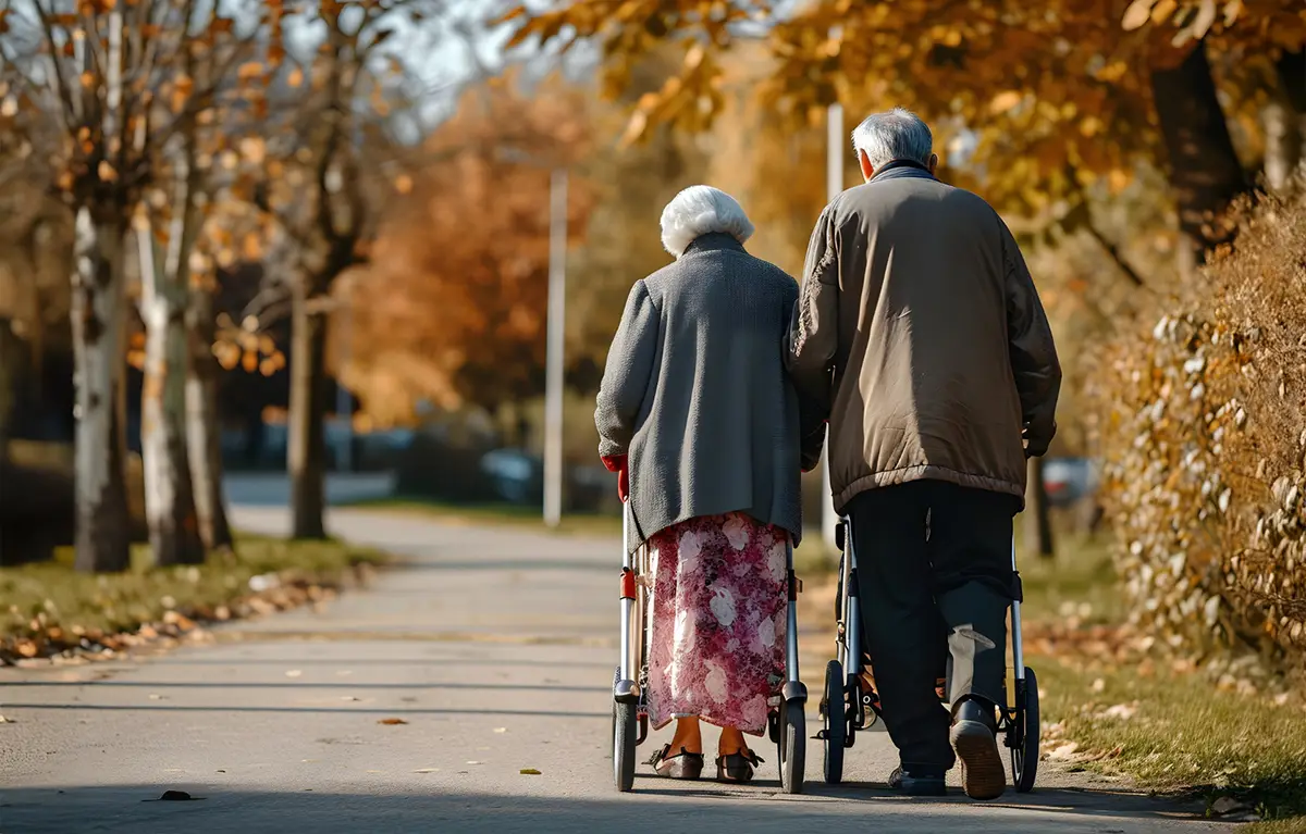 Stari muškarac i žena u šetnji s pomagalima, prikazani s leđa. Gerijatrijska ambulanta u bolnici u Dugoj Resi