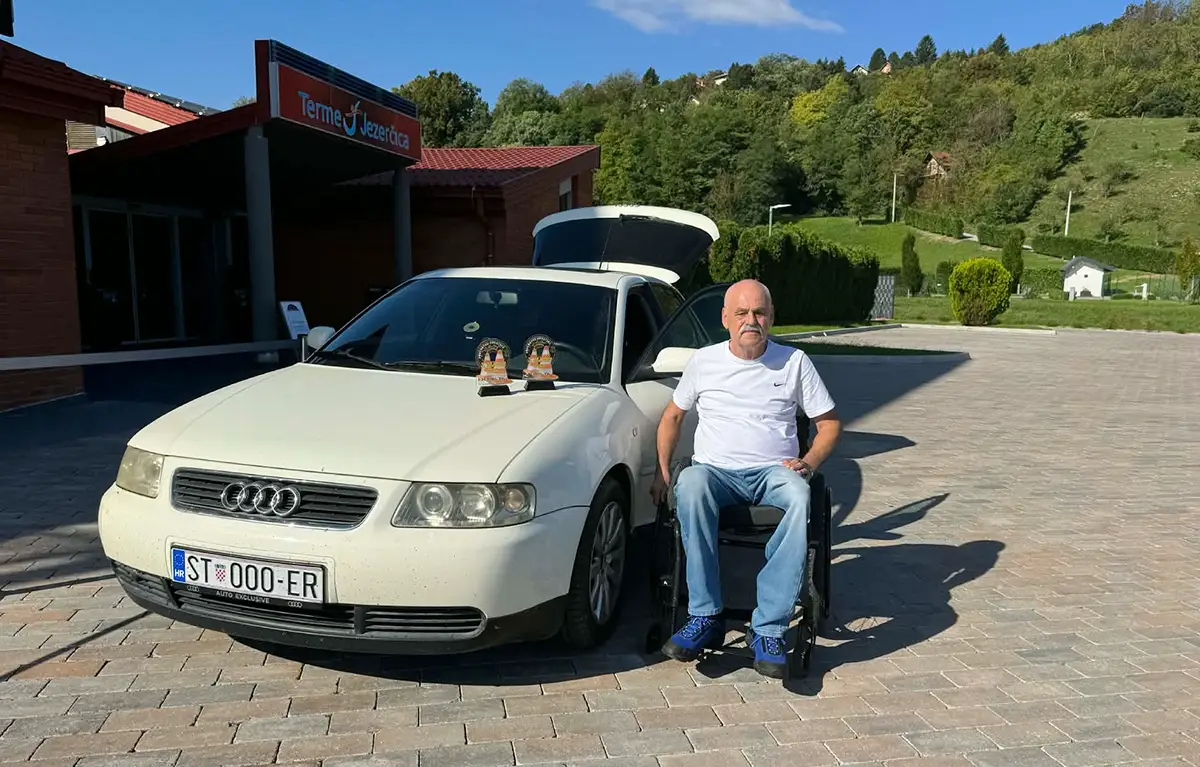 Edi Rožić u invalidskim kolicima pozira uz svoj sportski automobil