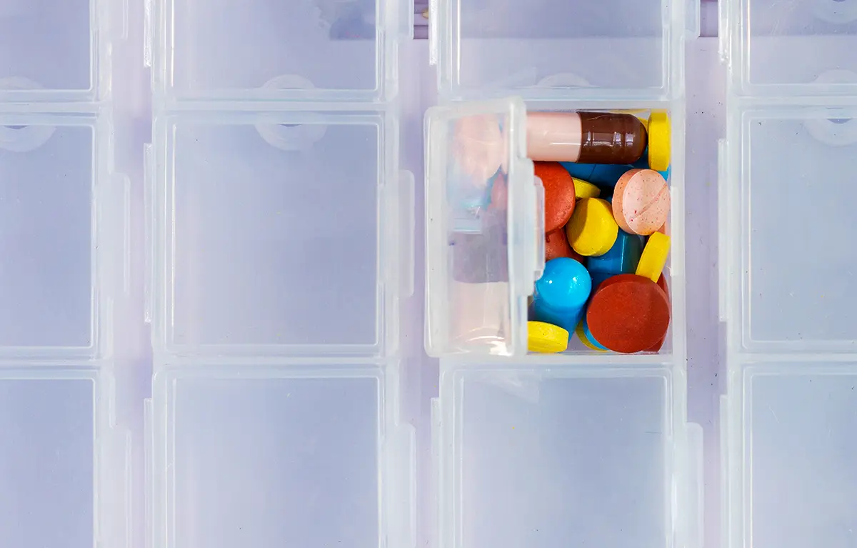 Različite tablete u jednom odjeljku spremnika za tablete; koncept generički lijekovi i otpadne vode prema Direktivi Europske komisije