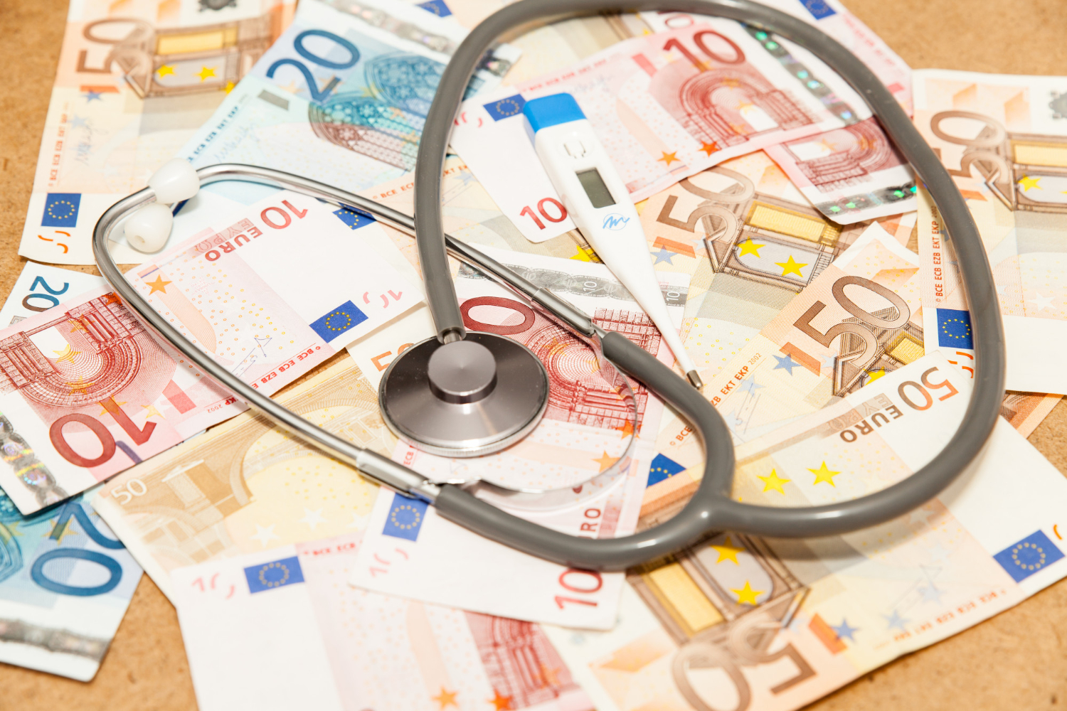Novčanice eura i liječnički stetoskop. Koncept milijuni u zdravstvu i sukob udruga