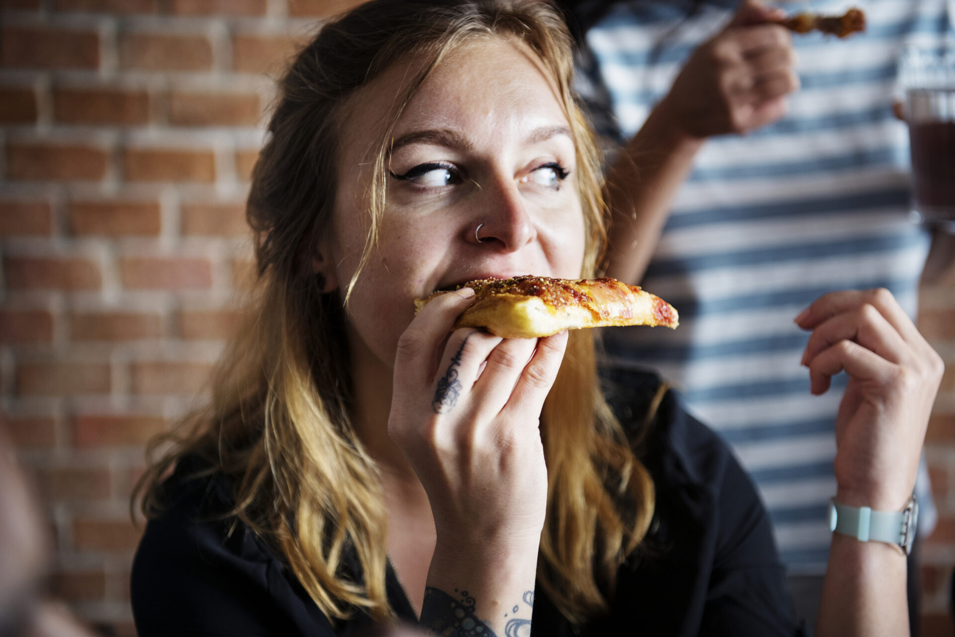 Ugljikohidrati i mršavljenje Žena grize komad pizze. Koncept ugljikohidrati u prehrani i mršavljenje.